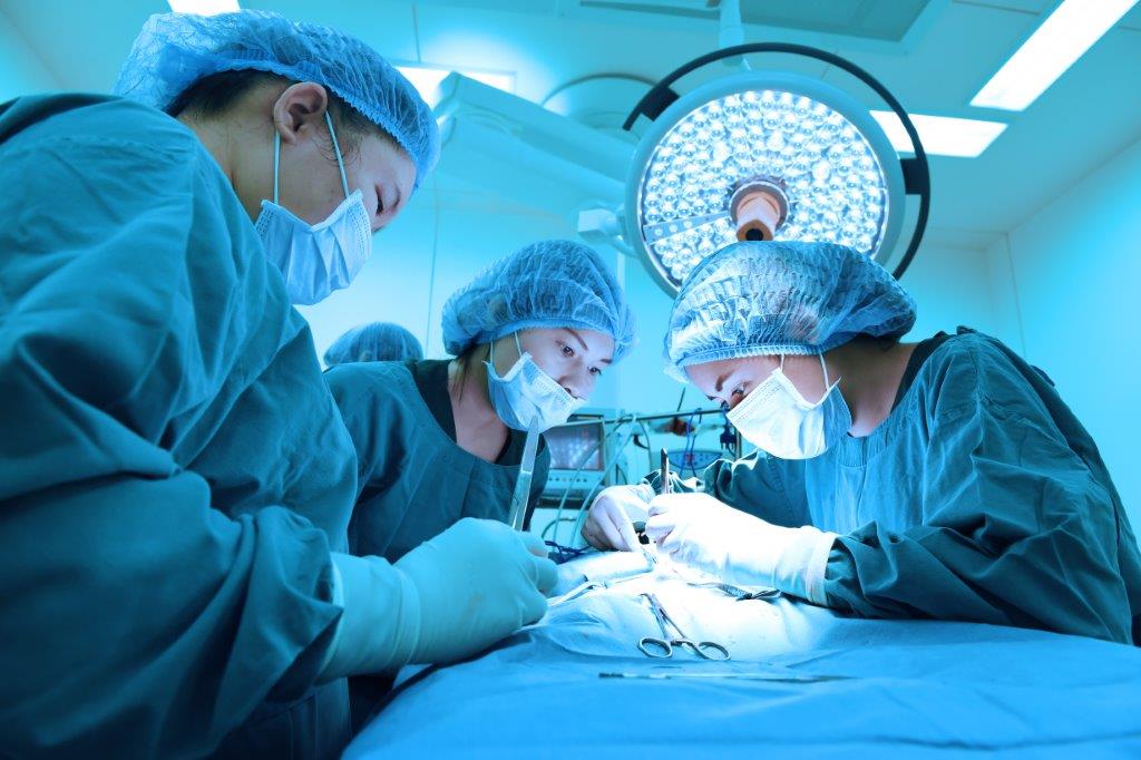 Three surgeons performing a surgical procedure.